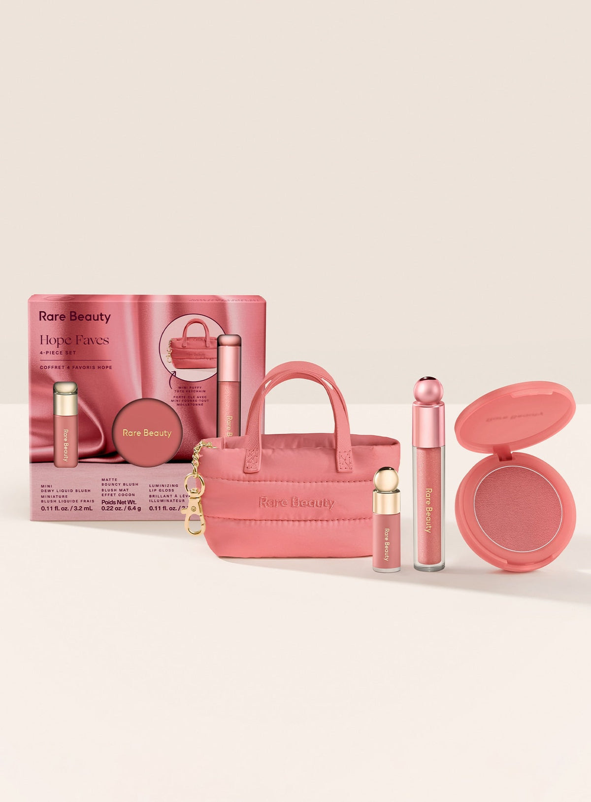 Rare Beauty Hope Faves, set de maquillaje con caja rosa, dos rubores, gloss y llavero Mini Puffy Tote