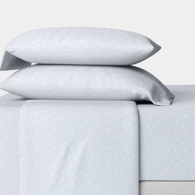 Wondershop Holiday Flannel Sheet Set, Light blue colored sheet set with small white snowflake pattern shown on a bed, featuring two stacked… #color_WS Blue Snowflake Reactive