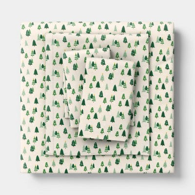 Wondershop Holiday Flannel Sheet Set, Sheet set folded and stacked, featuring a cream colored background printed with small green colored… #color_WS Trees
