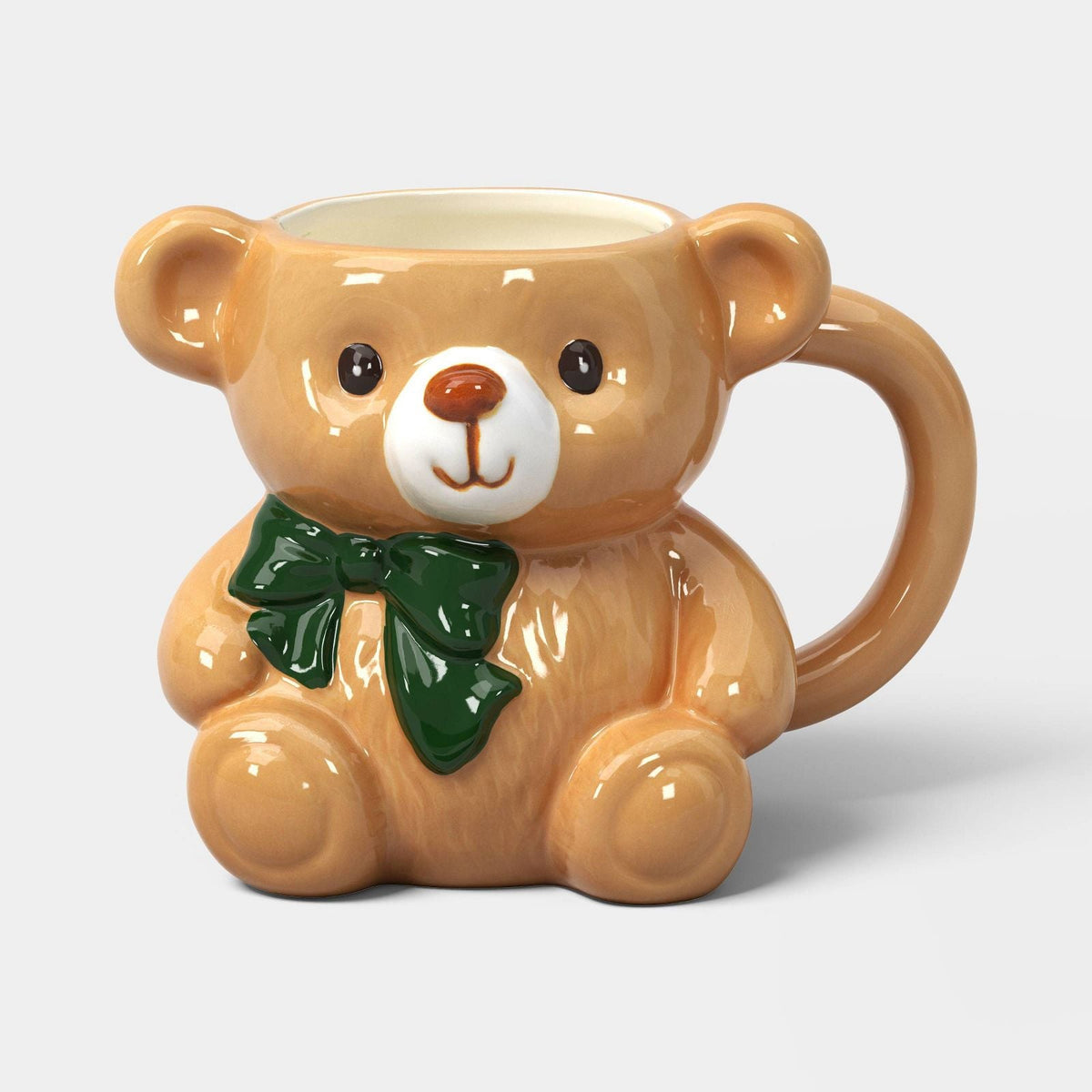 Taza navideña Wondershop de cerámica, oso café con hocico blanco y moño verde, vista frontal #tamaño_473 ml / 16 fl oz