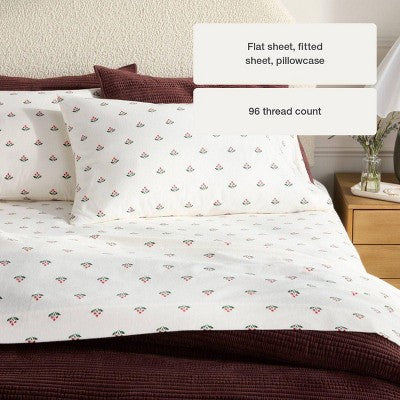 Threshold Holiday Flannel Sheet Set, White colored sheet set with small red and green berry motifs on a made bed paired with a dark red… #color_THRESHOLD Berry