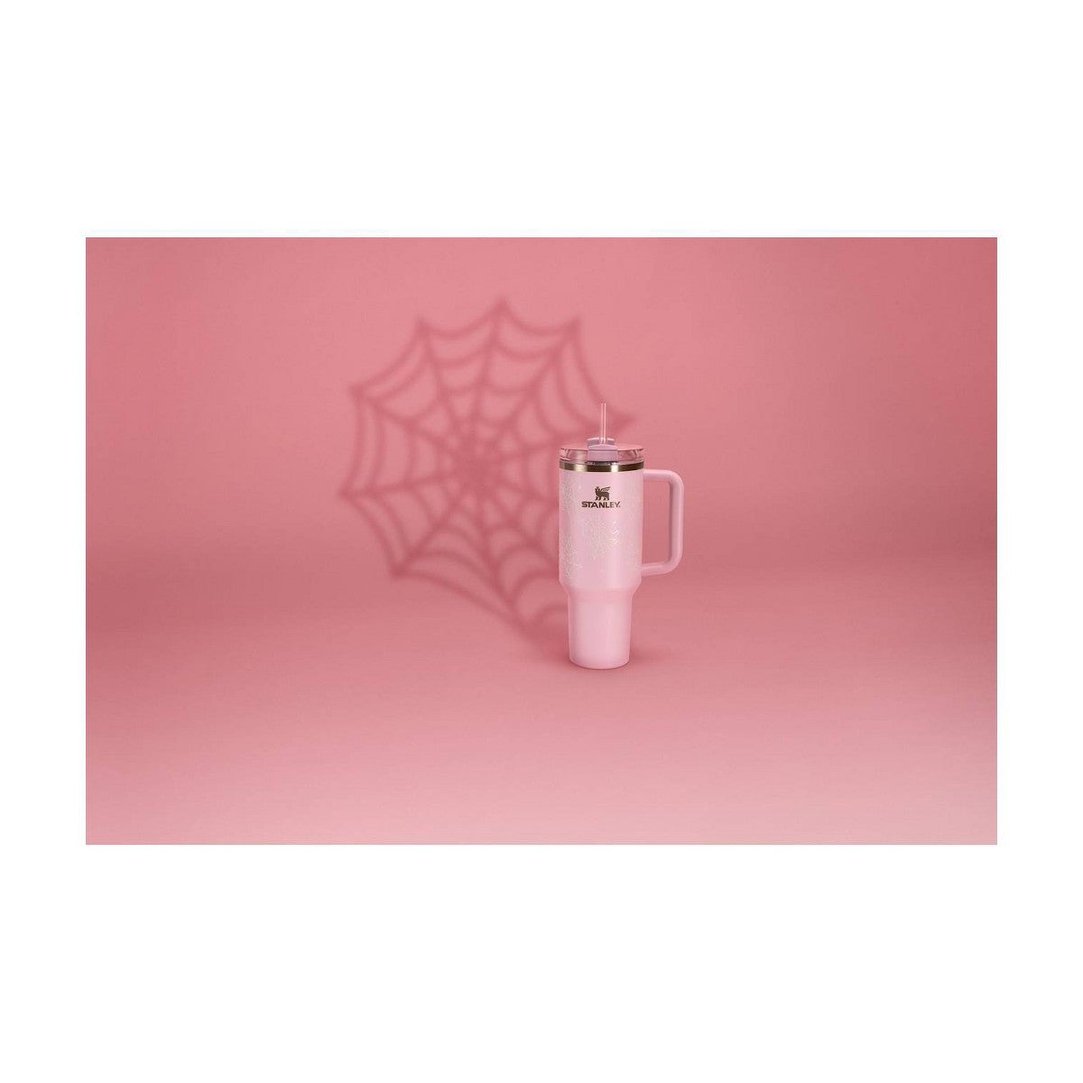 Stanley Quencher rosa Pink Sugar Spider Webs sobre fondo rosa con sombra de telaraña